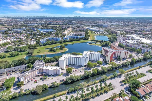 an aerial view of a city with lots of residential buildings ocean and mountain view in back
