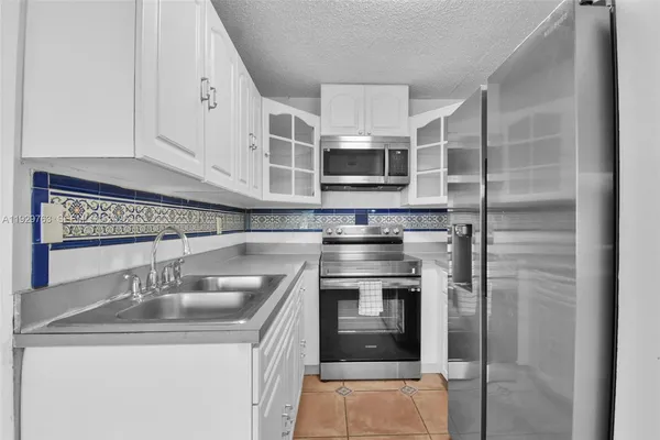 a kitchen with stainless steel appliances granite countertop a sink and a microwave