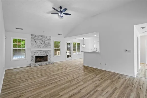 a view of empty room with wooden floor and fireplace