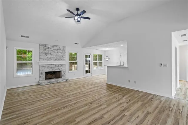 a view of empty room with wooden floor and fireplace