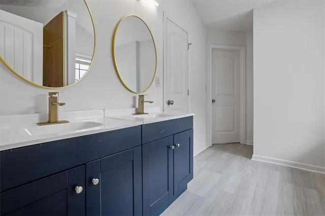 a en suite bathroom with a double vanity sink and a mirror