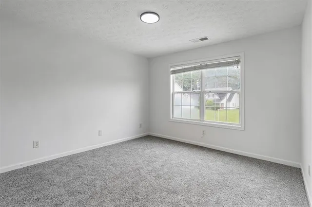 an empty room with windows and closet