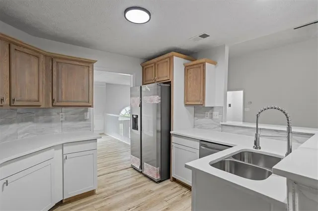 a kitchen with a refrigerator sink and cabinets