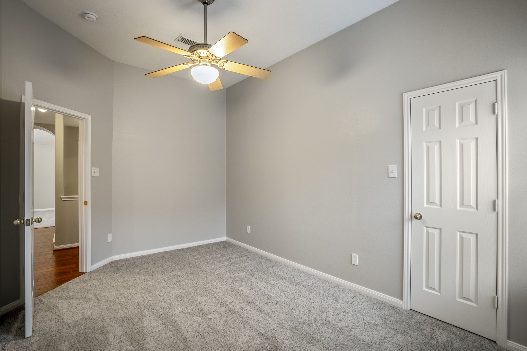 6311 Sparrows Glen Lane Spring, TX 77379 - Photo 27 of 50 Moving down the upstairs hall, this bedroom keeps the second floor feeling light and easy, with soft carpet, a ceiling fan, and closet storage along the right wall. The open doorway leads back toward the gameroom and full bath nearby.