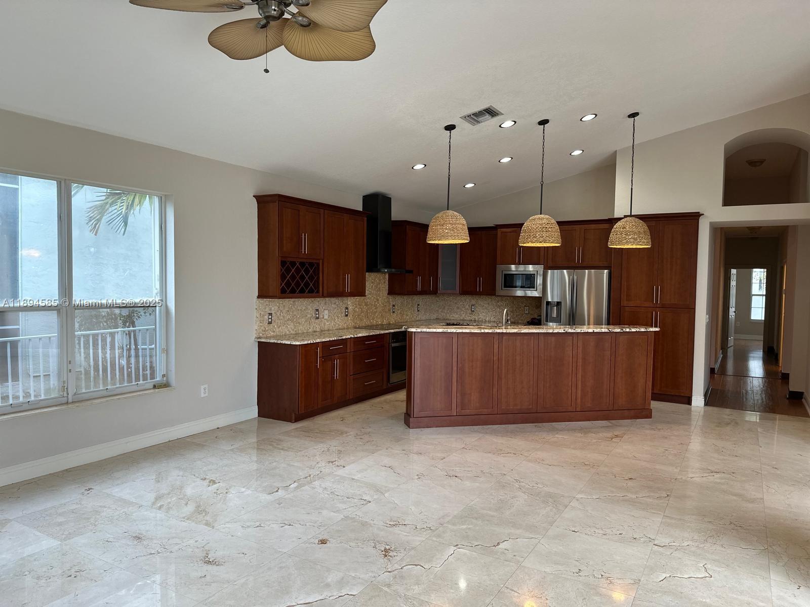 a large kitchen with a large counter top stainless steel appliances and cabinets