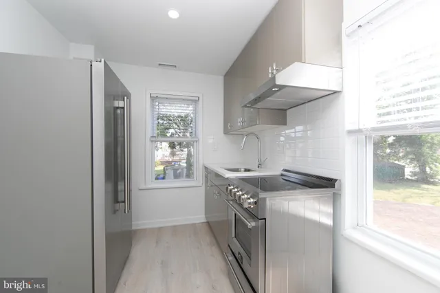 a kitchen with stainless steel appliances a refrigerator and a window