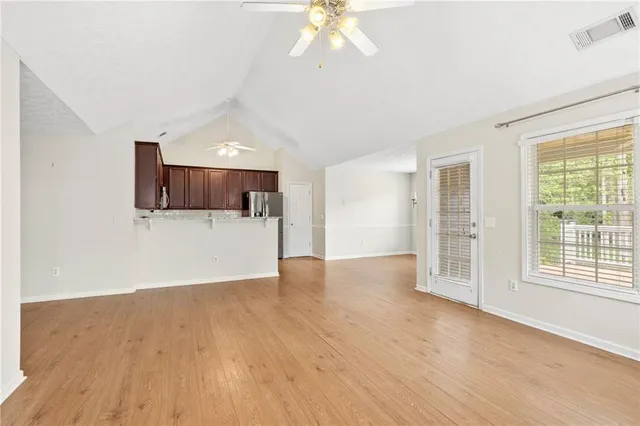 a view of a kitchen with wooden floor and a ceiling fan