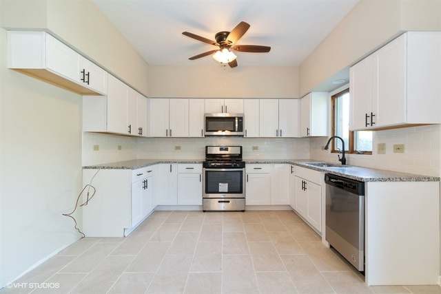 154 Bent Tree Lane New Lenox, IL 60451 - Photo 9 of 25 a kitchen with granite countertop white cabinets and white appliances