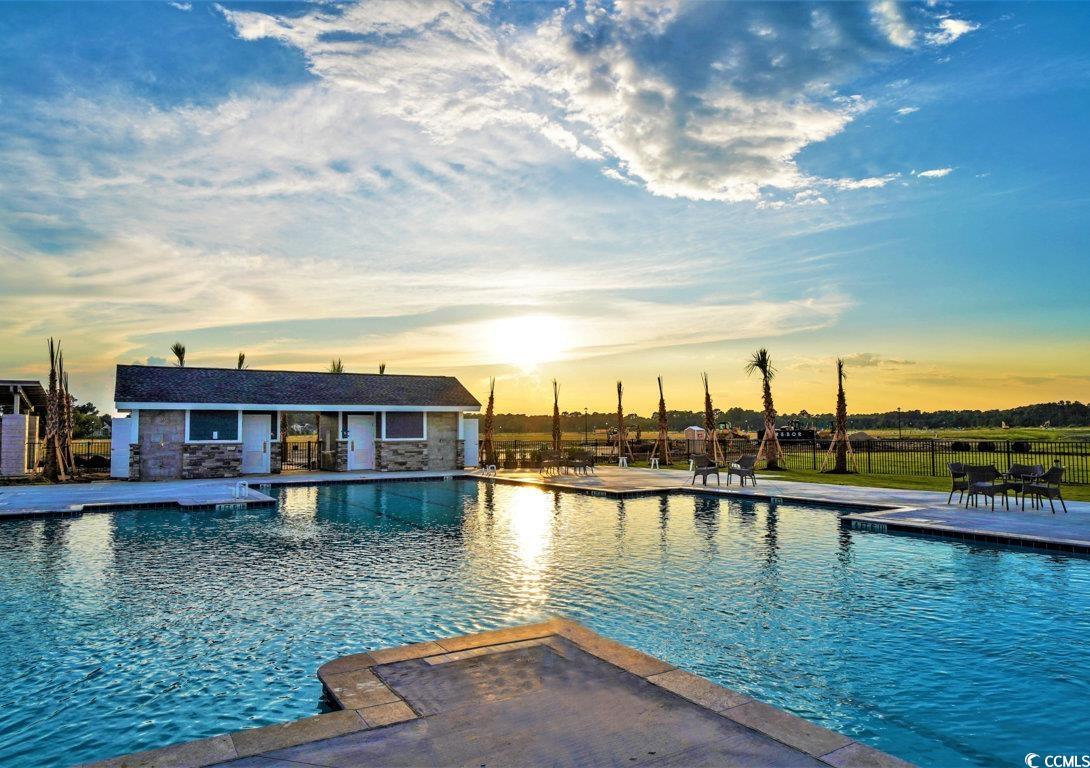 712 St Vincent Loop Little River, SC 29566 - Photo 6 of 10 Pool at dusk with a community pool and a patio