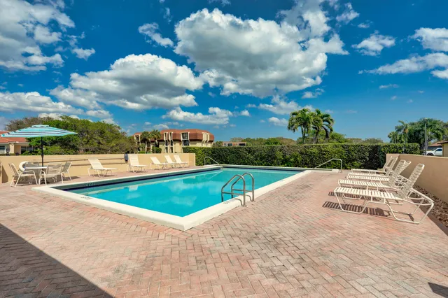 a view of a house with a big yard and large trees