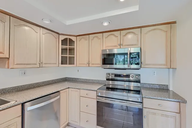 a dining room with furniture floor to ceiling windows and wooden floor