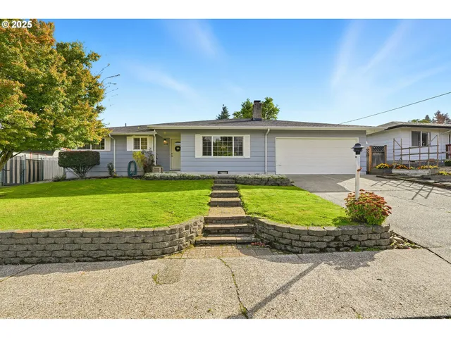 a view of a house with a yard and potted plants