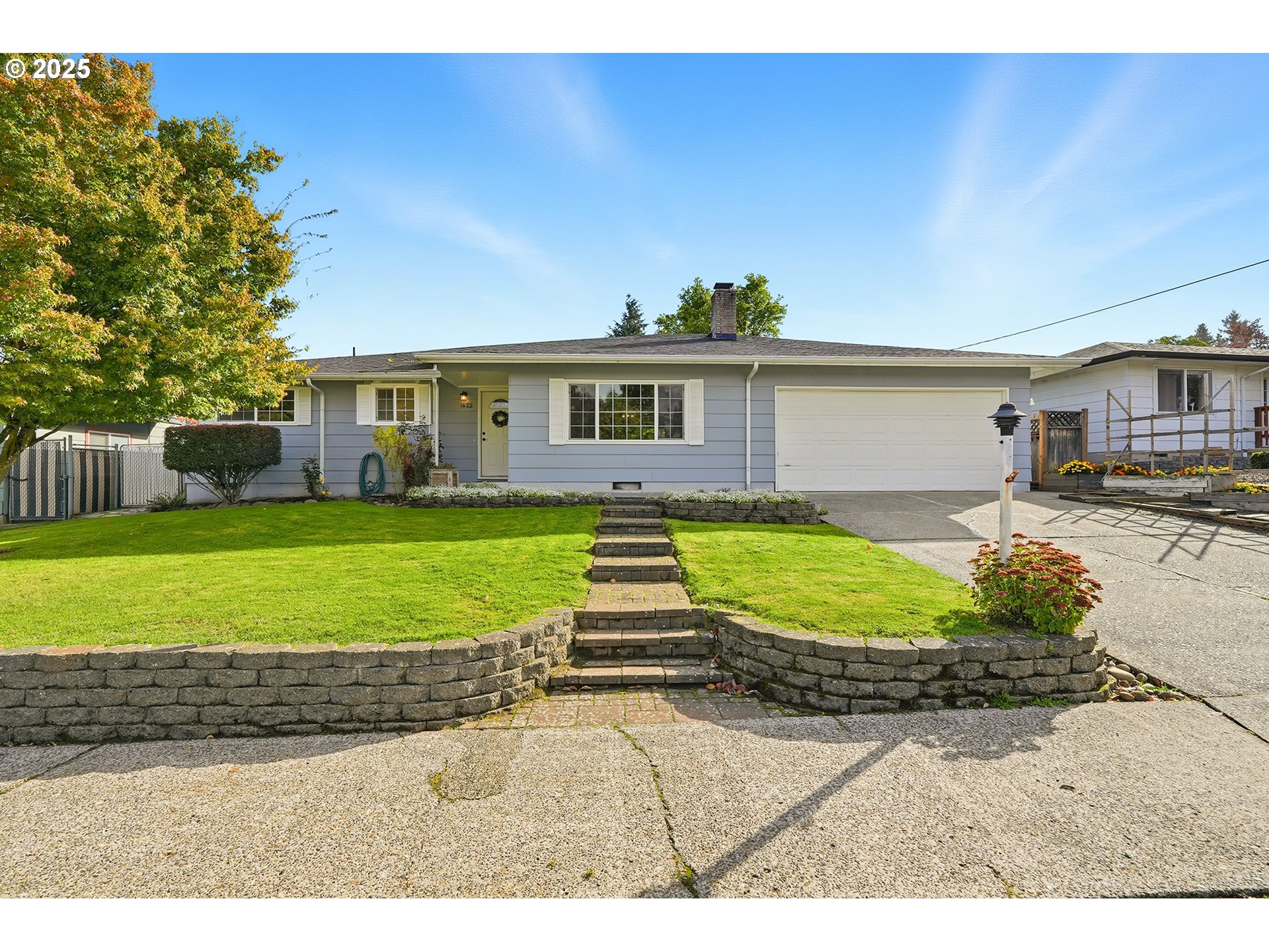 a view of a house with a yard and potted plants