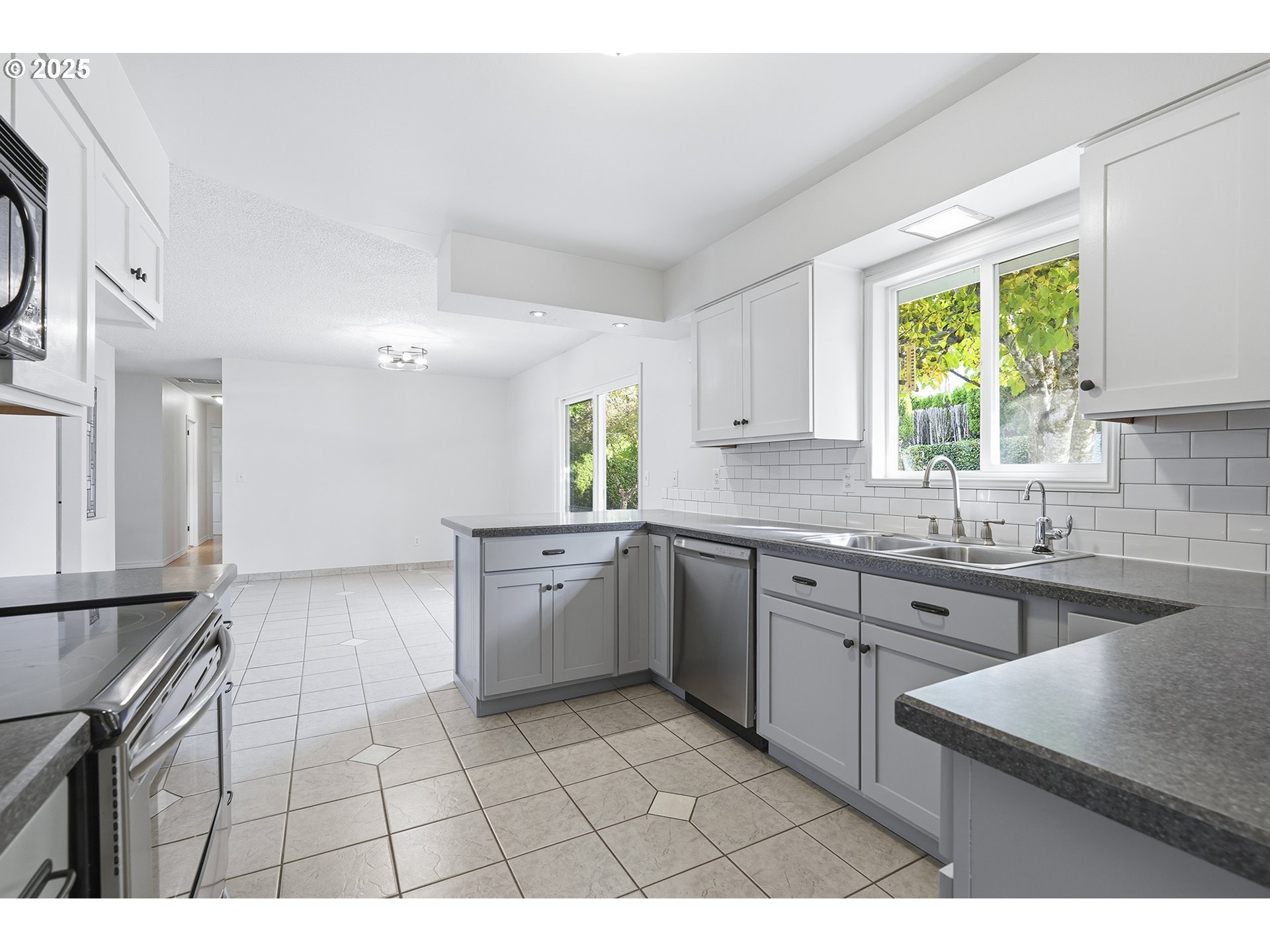 1422 Southeast 209th Avenue Gresham, OR 97030 - Photo 22 of 46 a kitchen with a sink a stove a microwave cabinets and a window