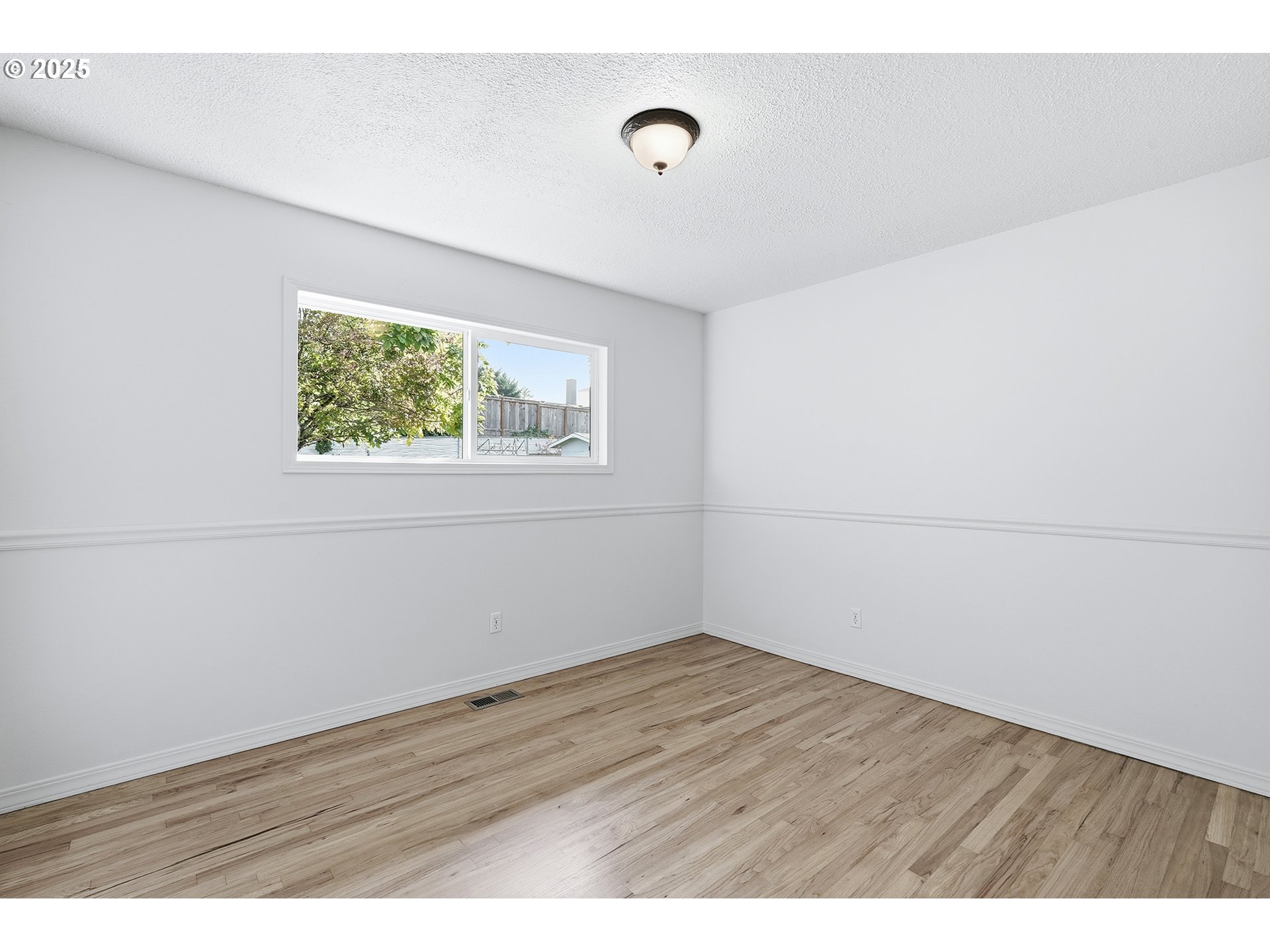 1422 Southeast 209th Avenue Gresham, OR 97030 - Photo 25 of 46 a view of an empty room with wooden floor and a window