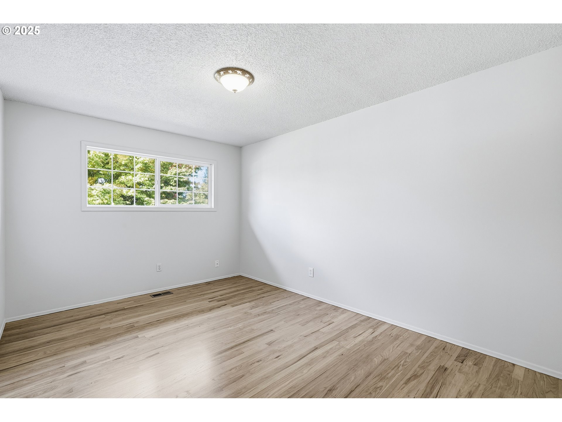 1422 Southeast 209th Avenue Gresham, OR 97030 - Photo 31 of 46 a view of an empty room with wooden floor and a window