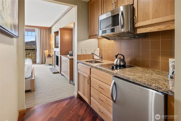 a kitchen with stainless steel appliances granite countertop a sink a stove and refrigerator