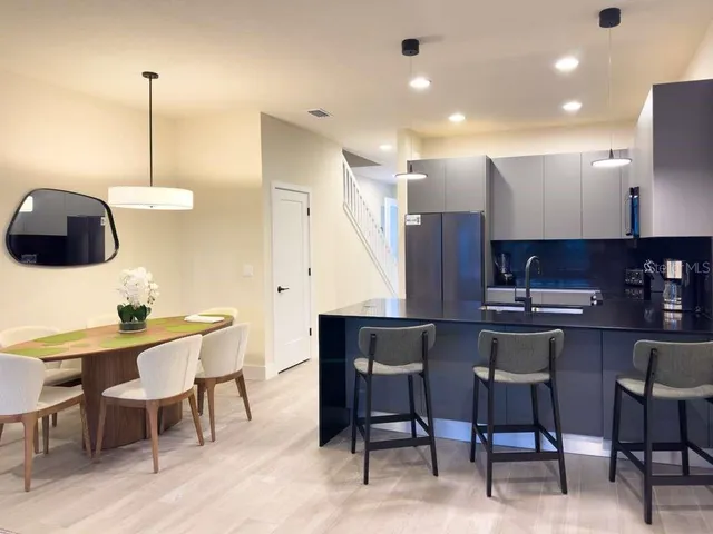 a kitchen with stainless steel appliances kitchen island a table and chairs in it