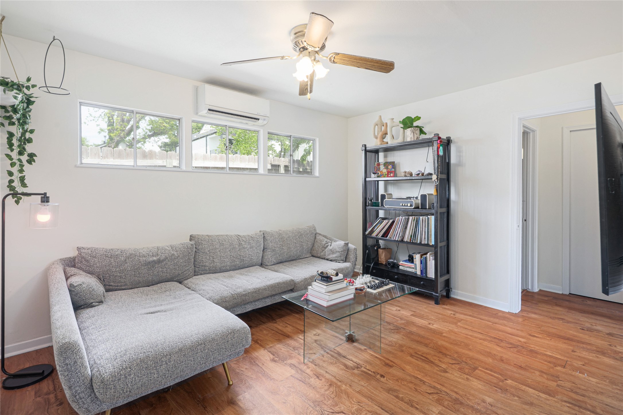 4607 Evans Avenue, Unit B Austin, TX 78751 - Photo 8 of 34 Bright living area featuring wood-finish flooring, white walls, multiple windows, and a ceiling fan