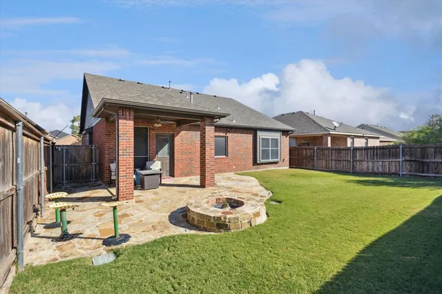 a backyard of a house with table and chairs