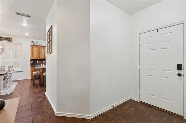 a view of a hallway with wooden floor and a bathroom