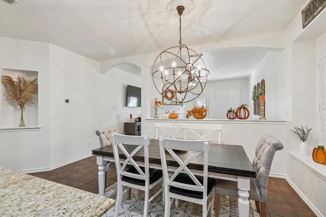 a kitchen with stainless steel appliances granite countertop a sink a stove a dining table chairs and window