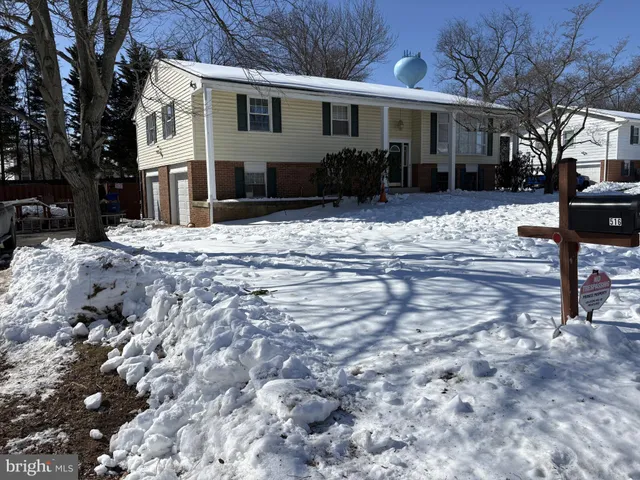 a front view of a house with a yard covered with snow
