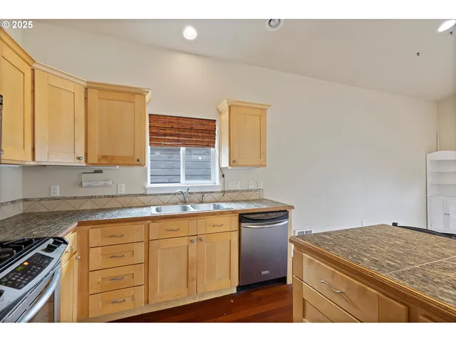 a kitchen with granite countertop a sink stove and cabinets