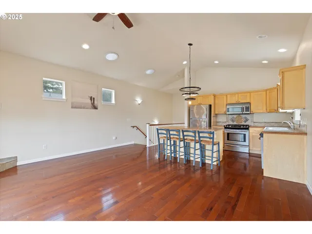 a kitchen with stainless steel appliances a dining table chairs stove and white cabinets