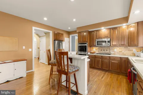 a kitchen with stainless steel appliances granite countertop wooden cabinets a stove top oven a sink and dishwasher