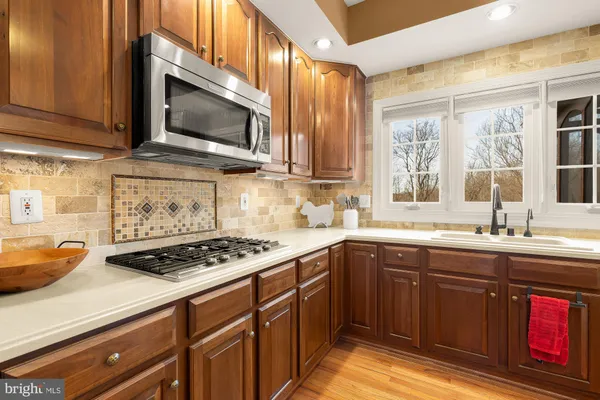 a kitchen with stainless steel appliances a sink stove and cabinets
