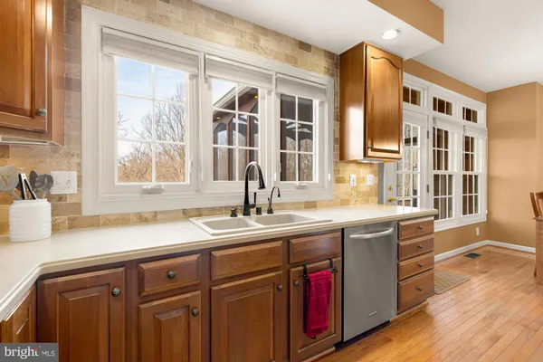 a kitchen with stainless steel appliances granite countertop a sink and wooden cabinets
