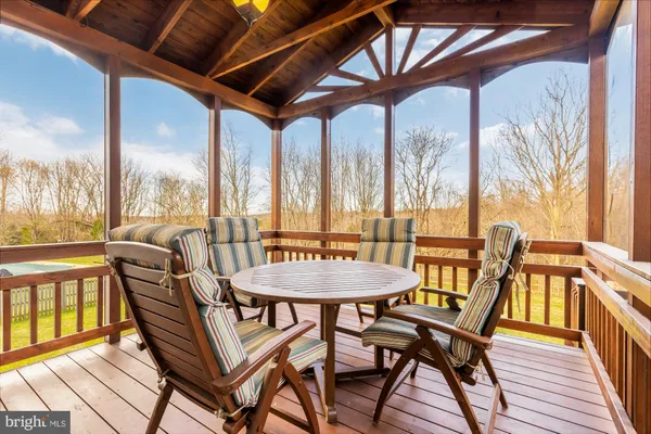 a view of a dining room with furniture a chandelier and wooden floor