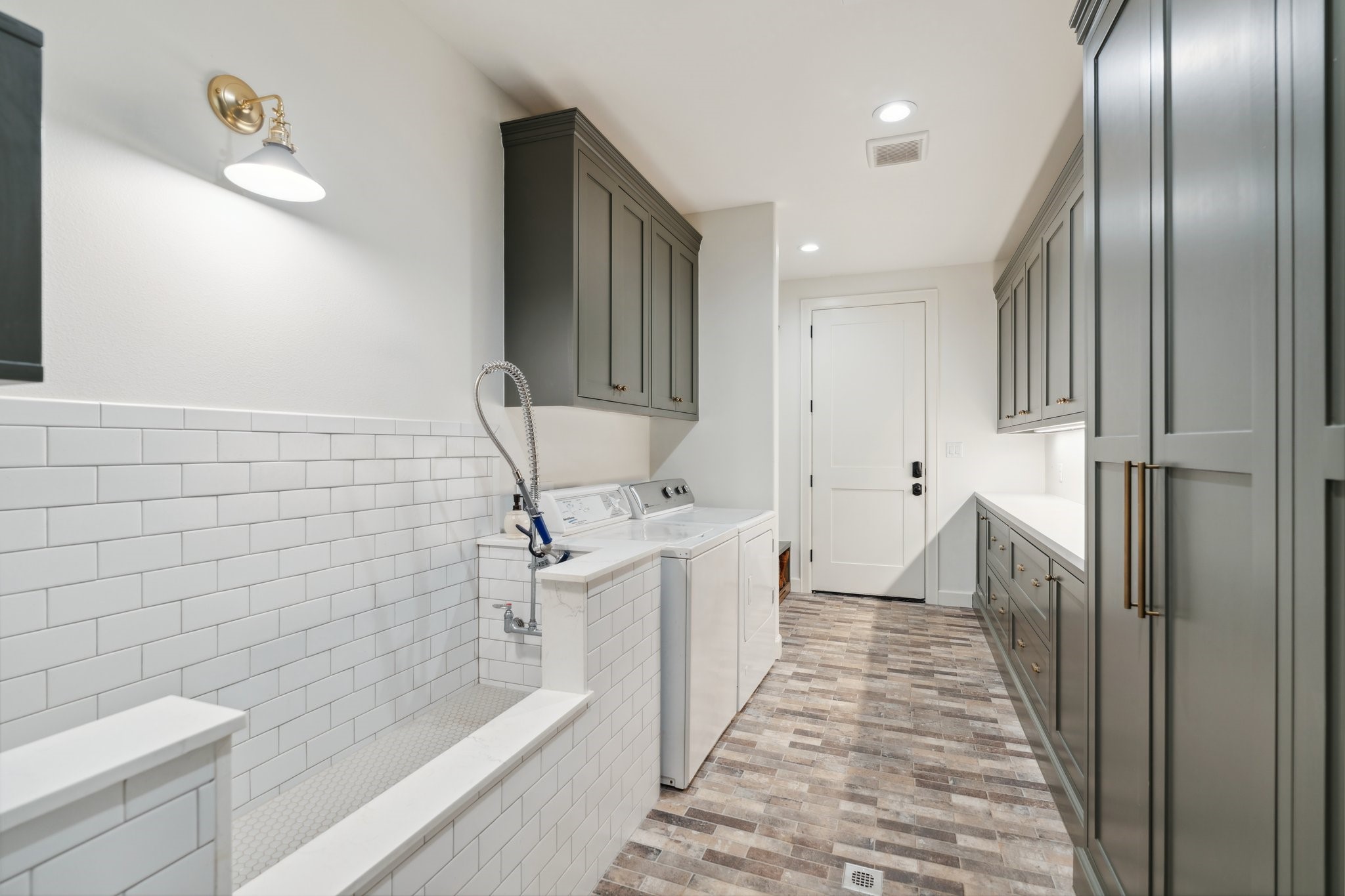 4052 Kuykendall Road Bellville, TX 77418 - Photo 15 of 40 This spacious laundry room offers ample storage and a convenient dog washing station, making it ideal for cleaning muddy boots and keeping your home tidy.