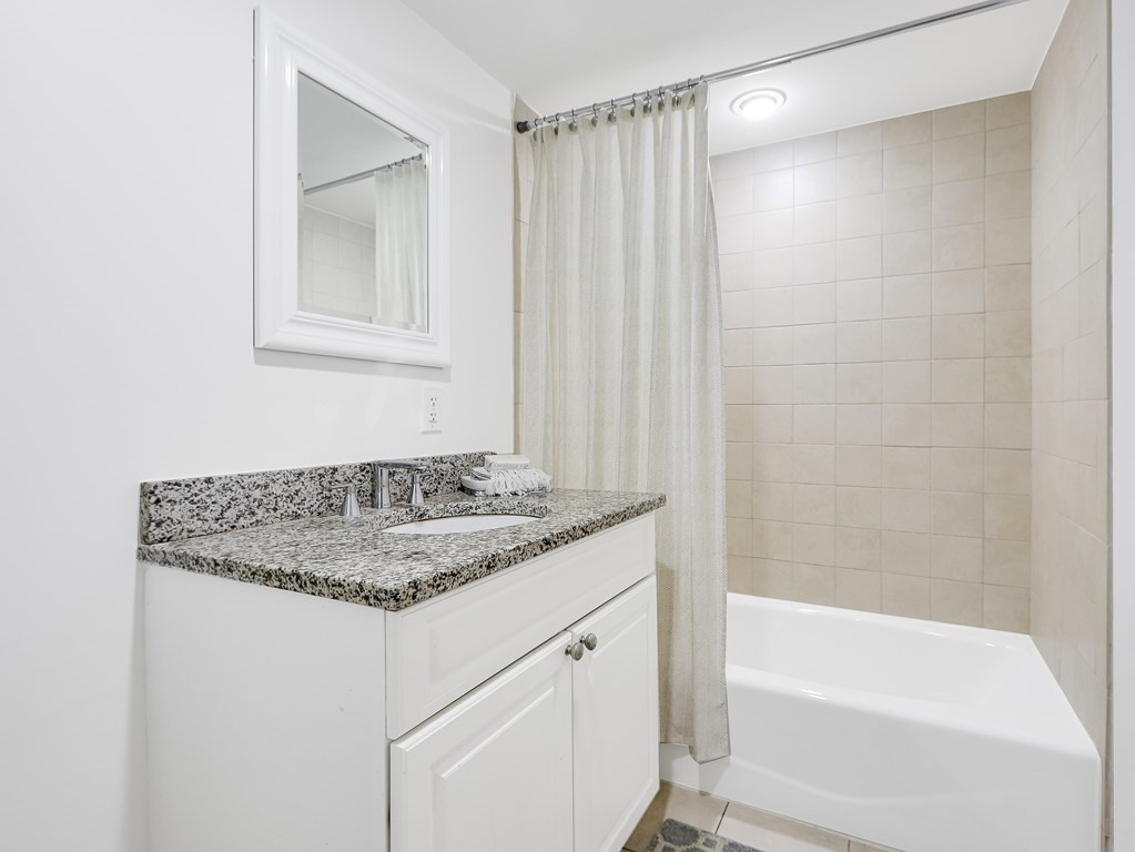 138 Middlesex Road, Unit B Newton, MA 02467 - Photo 13 of 16 a bathroom with a granite countertop sink and a bathtub