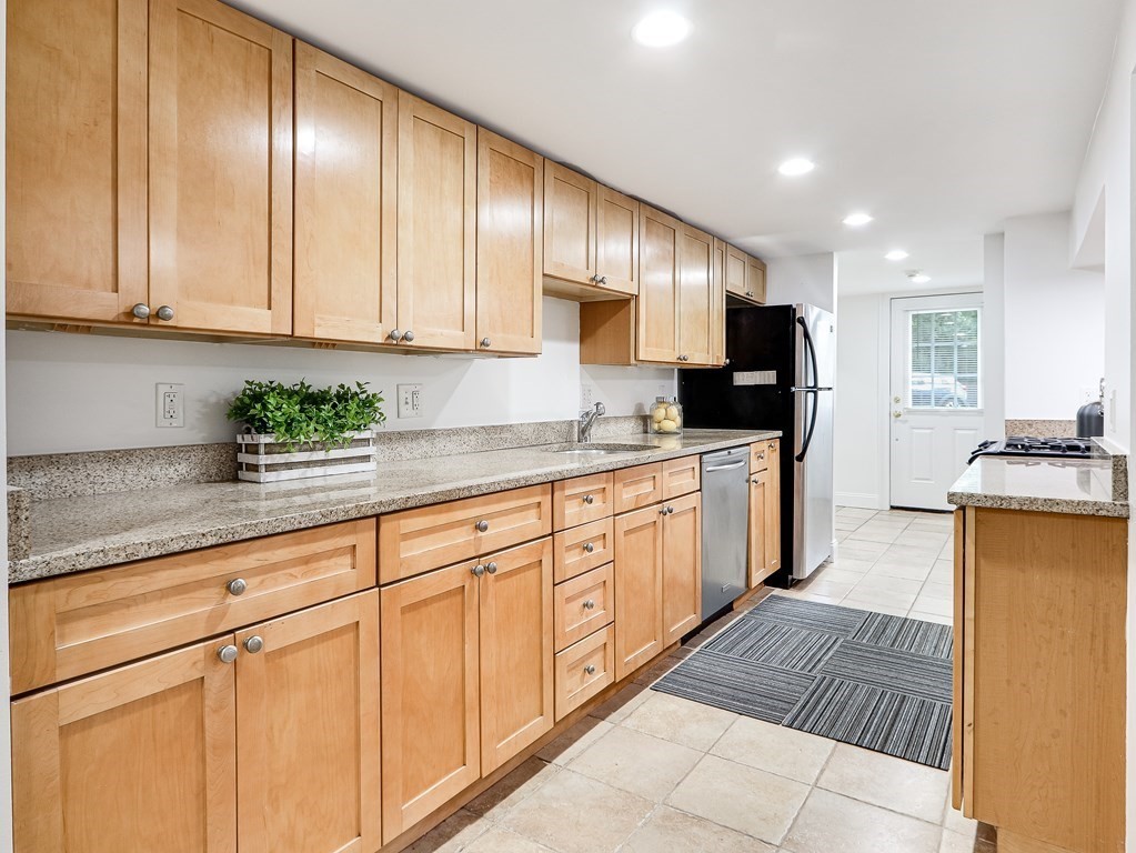 138 Middlesex Road, Unit B Newton, MA 02467 - Photo 6 of 16 a kitchen with granite countertop cabinets stainless steel appliances a sink and window