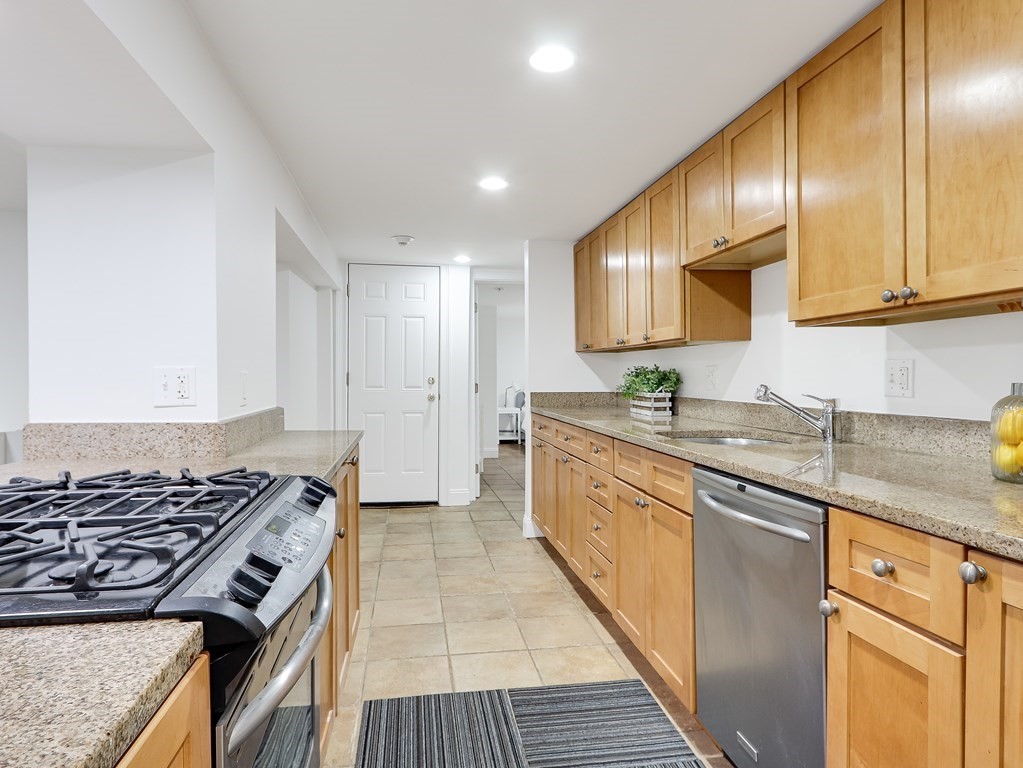 138 Middlesex Road, Unit B Newton, MA 02467 - Photo 7 of 16 a kitchen with granite countertop stainless steel appliances cabinets a sink and a counter top space