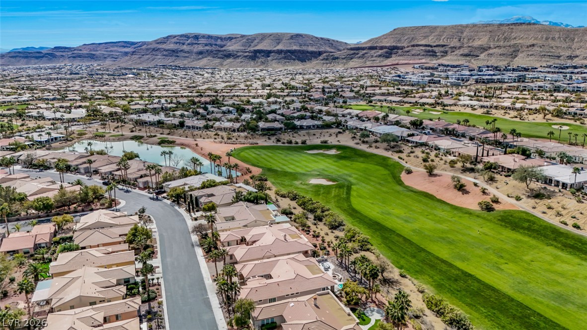 5015 Rivedro Street Las Vegas, NV 89135 - Photo 72 of 91 An aerial perspective reveals a vibrant golf course community nestled against a backdrop of distant mountains.