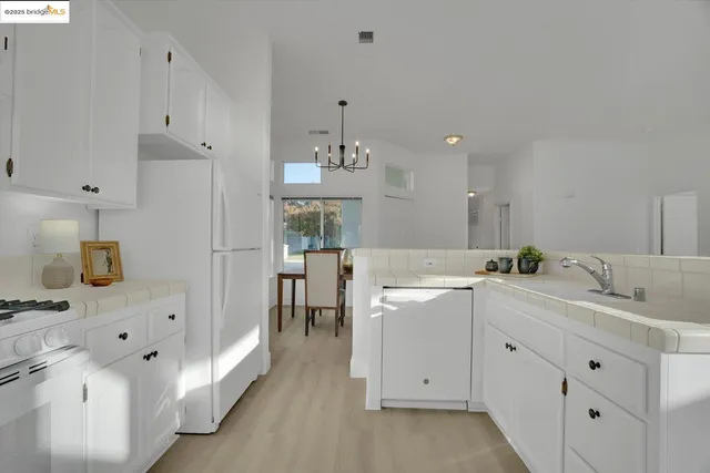 a kitchen with white cabinets and sink