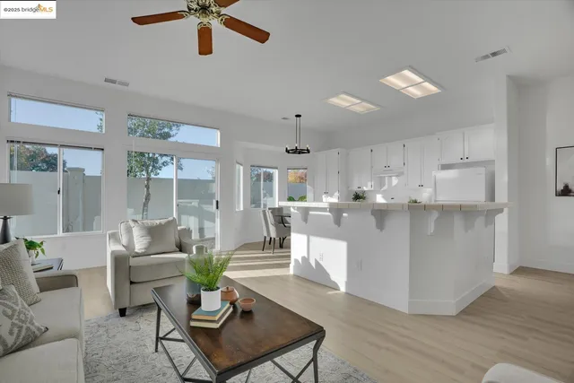 a living room with kitchen island furniture and a chandelier