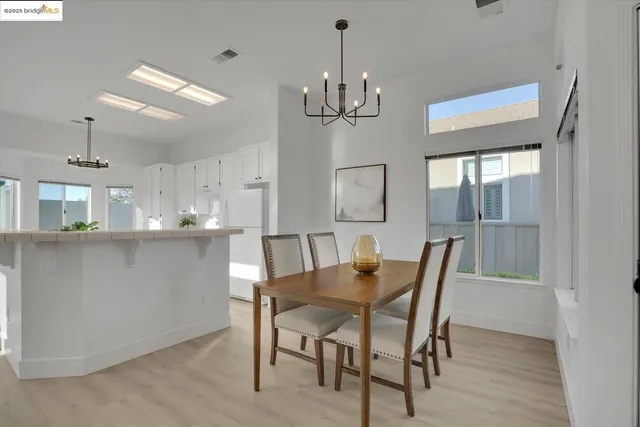 a view of a dining room with furniture a chandelier and wooden floor