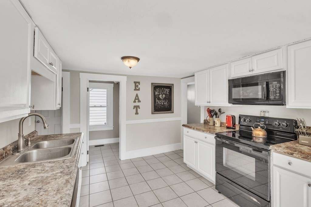 153 Pomeroy Meadow Road Southampton, MA 01073 - Photo 17 of 42 a kitchen with granite countertop a sink a stove and cabinets