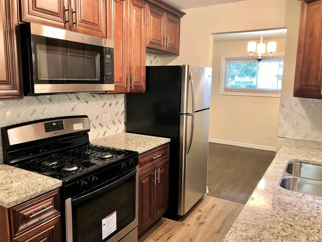 a kitchen with granite countertop a stove and a microwave
