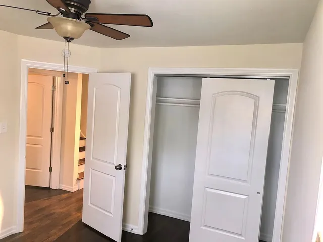a view of a hallway with wooden floor and entryway