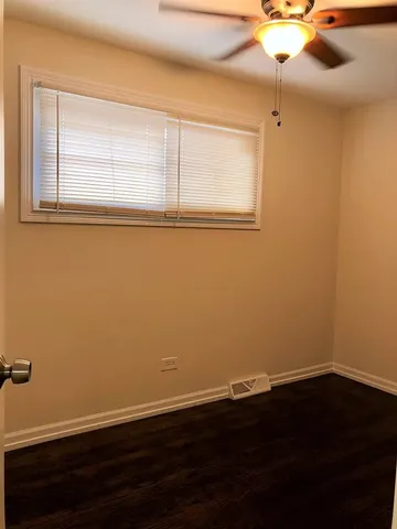 a view of a small space with wooden floor and windows