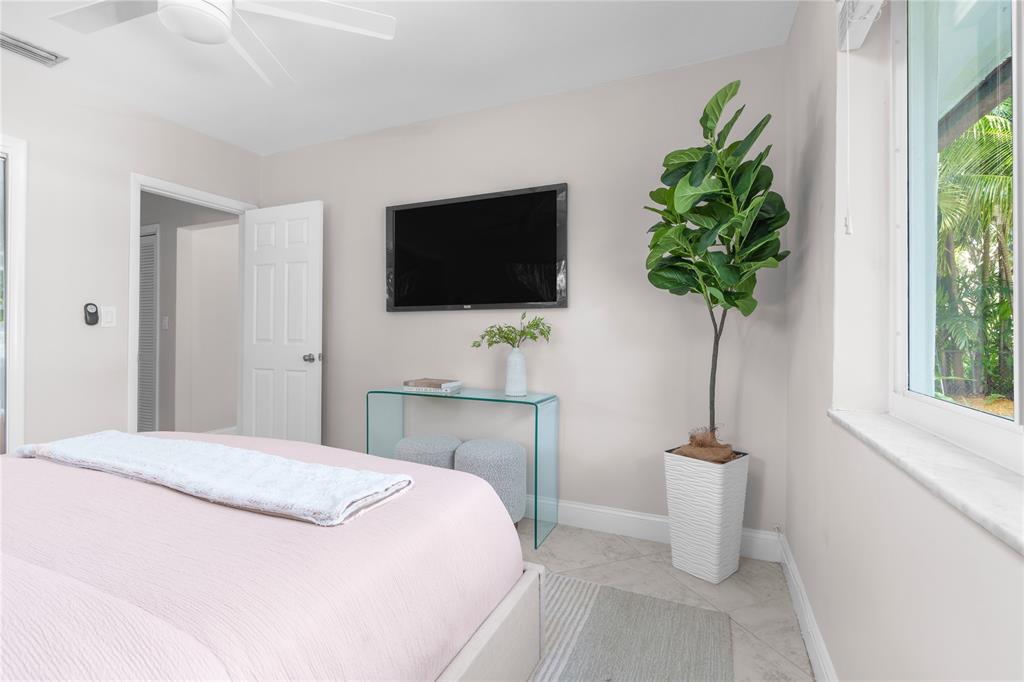 1502 Southwest 24th Street, Unit A Fort Lauderdale, FL 33315 - Photo 13 of 23 a bedroom with a bed a television and a window