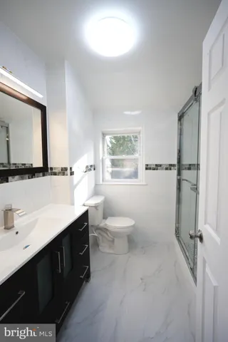 a bathroom with a toilet sink a mirror and a window