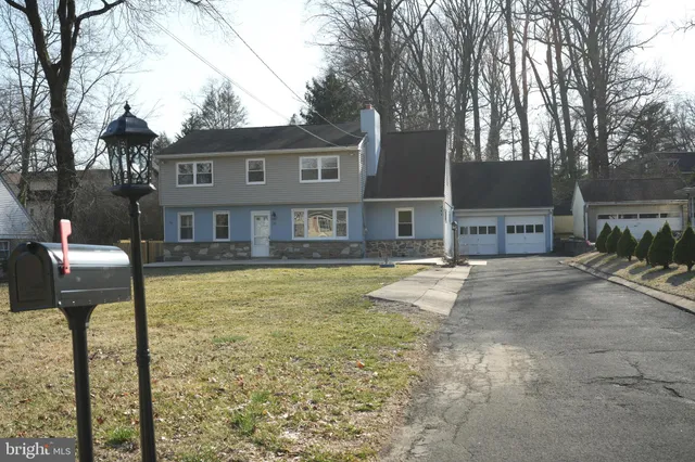 a front view of a house with a yard and trees