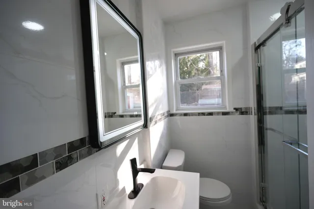 a bathroom with a toilet a sink and a large window