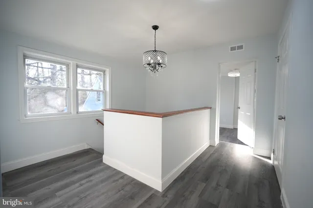 a view of a room with wooden floor and windows